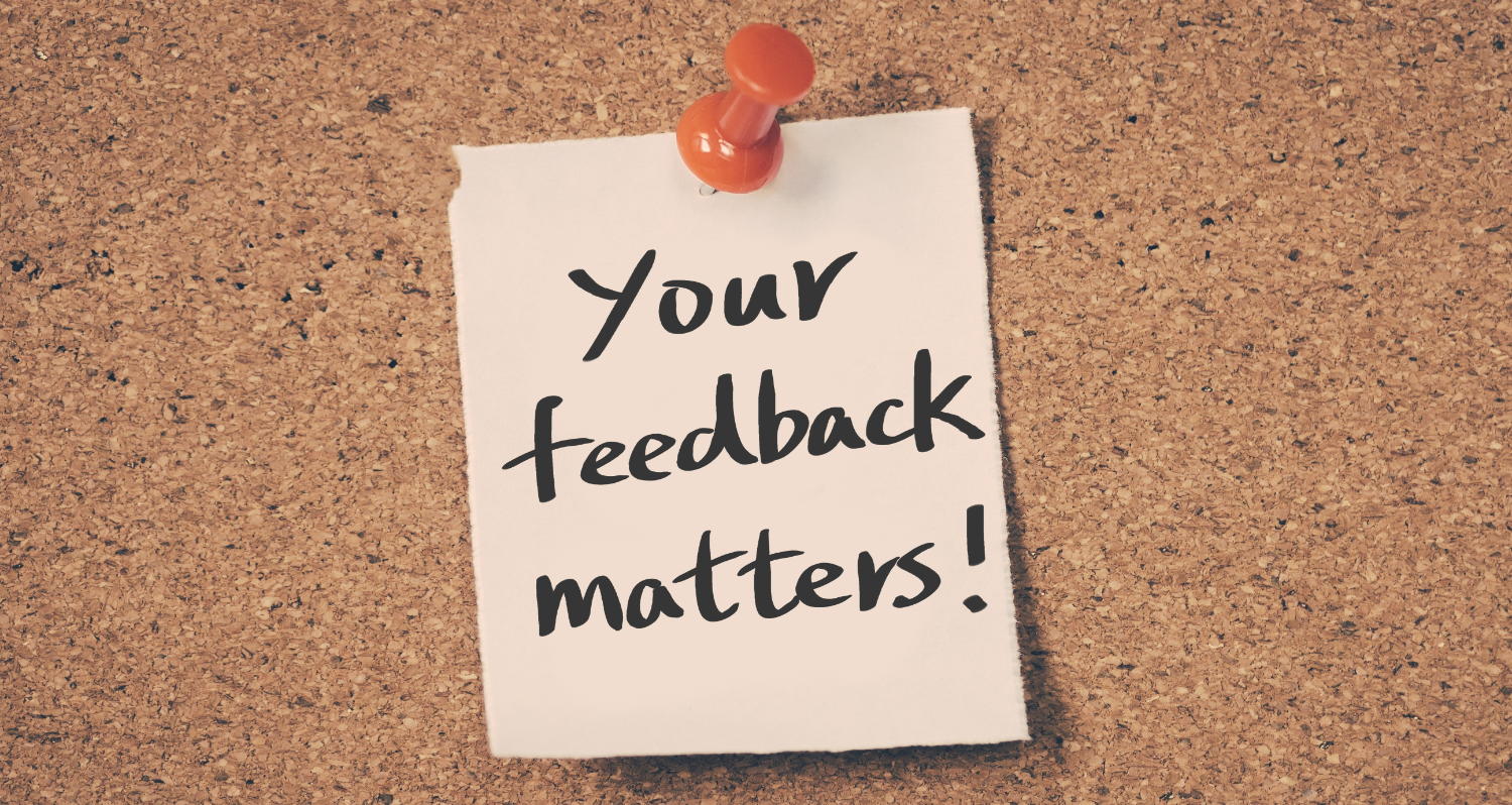 A note pinned to a cork board that reads "Your feedback matters!:
