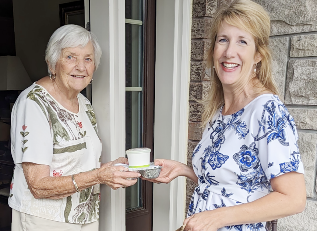 Mary June Smith greets a Meals on Wheels volunteer at her front door.